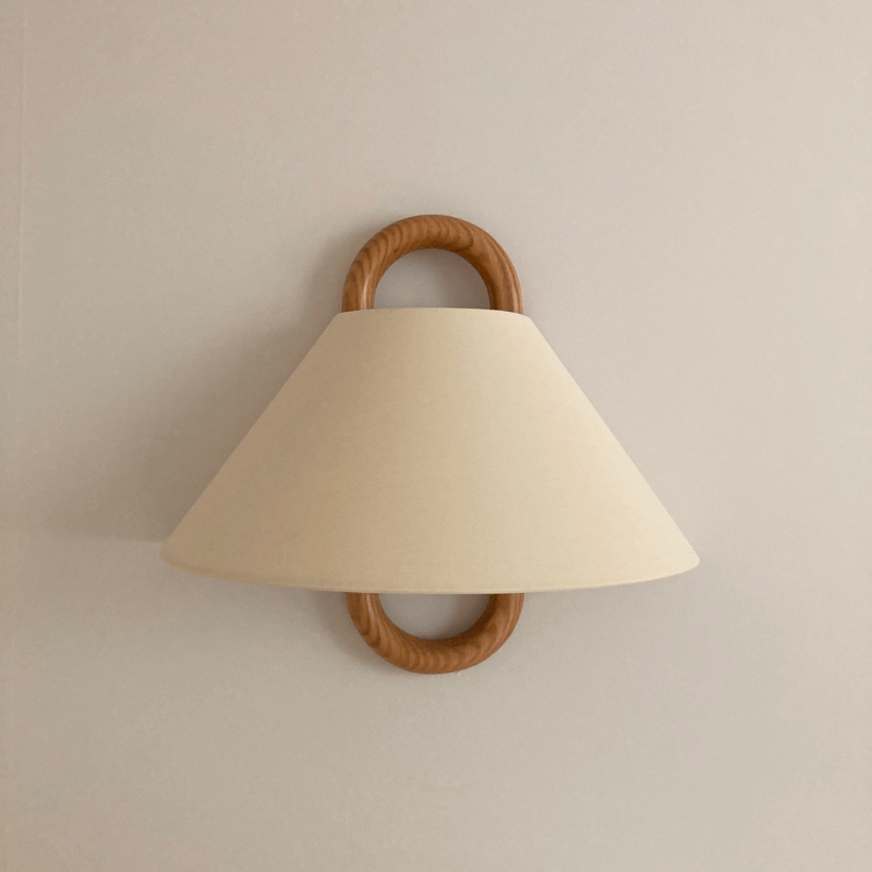 Close-up of pleated fabric shade texture on wood wall sconce | Casa Norex