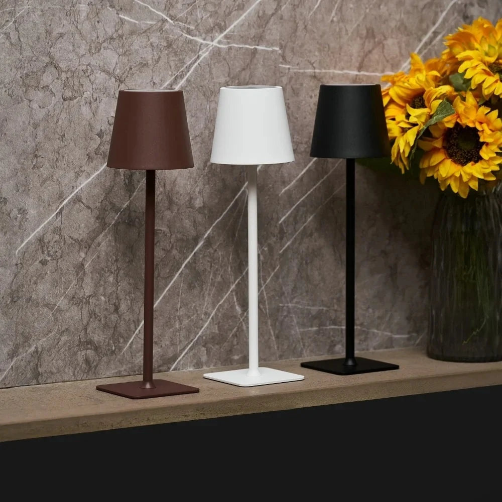 Three cordless table lamps in brown, white and black on a marble shelf — Casa Norex