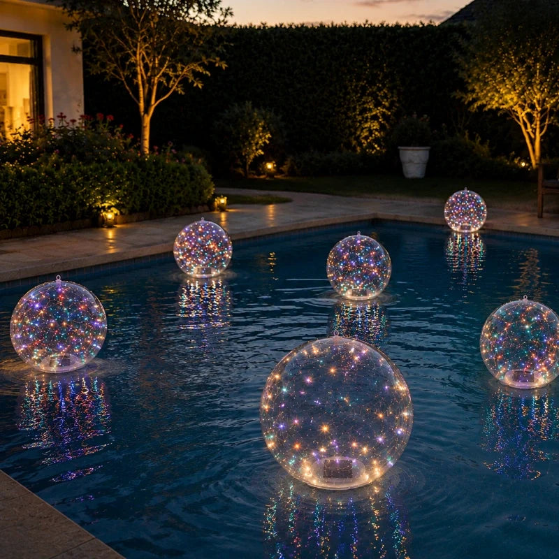 Multicolor floating solar light balls on a pool beside a garden at dusk