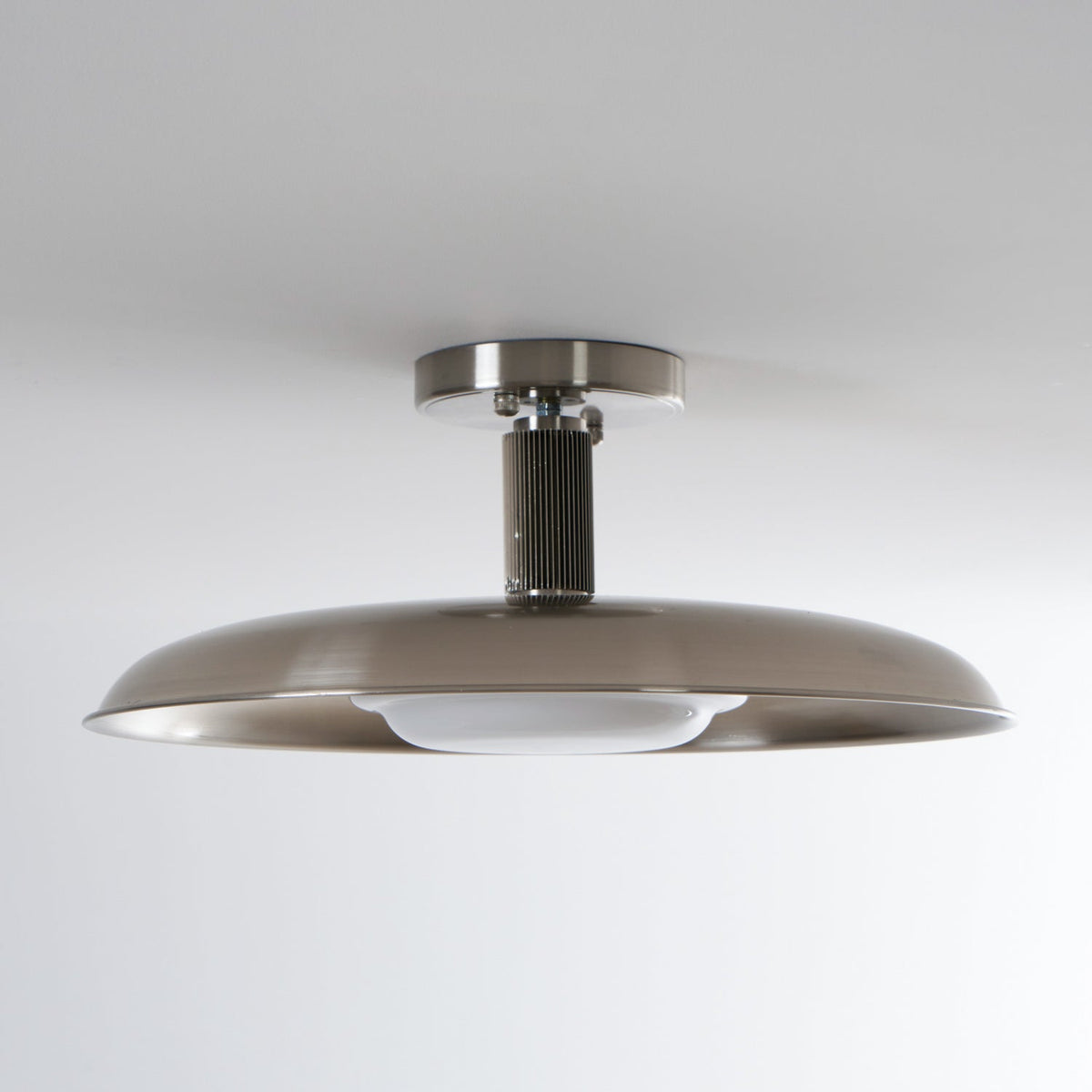 Polished nickel flush mount seen from the side on a grey ceiling — Casa Norex
