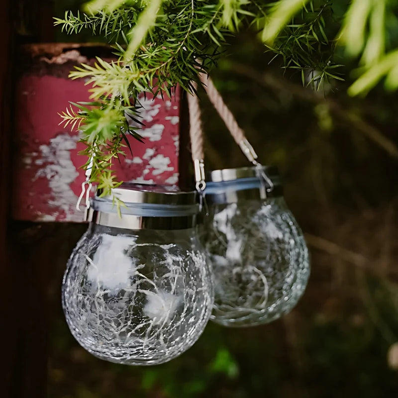 Clear crackle glass lanterns with rope handles hanging in daylight — Casa Norex