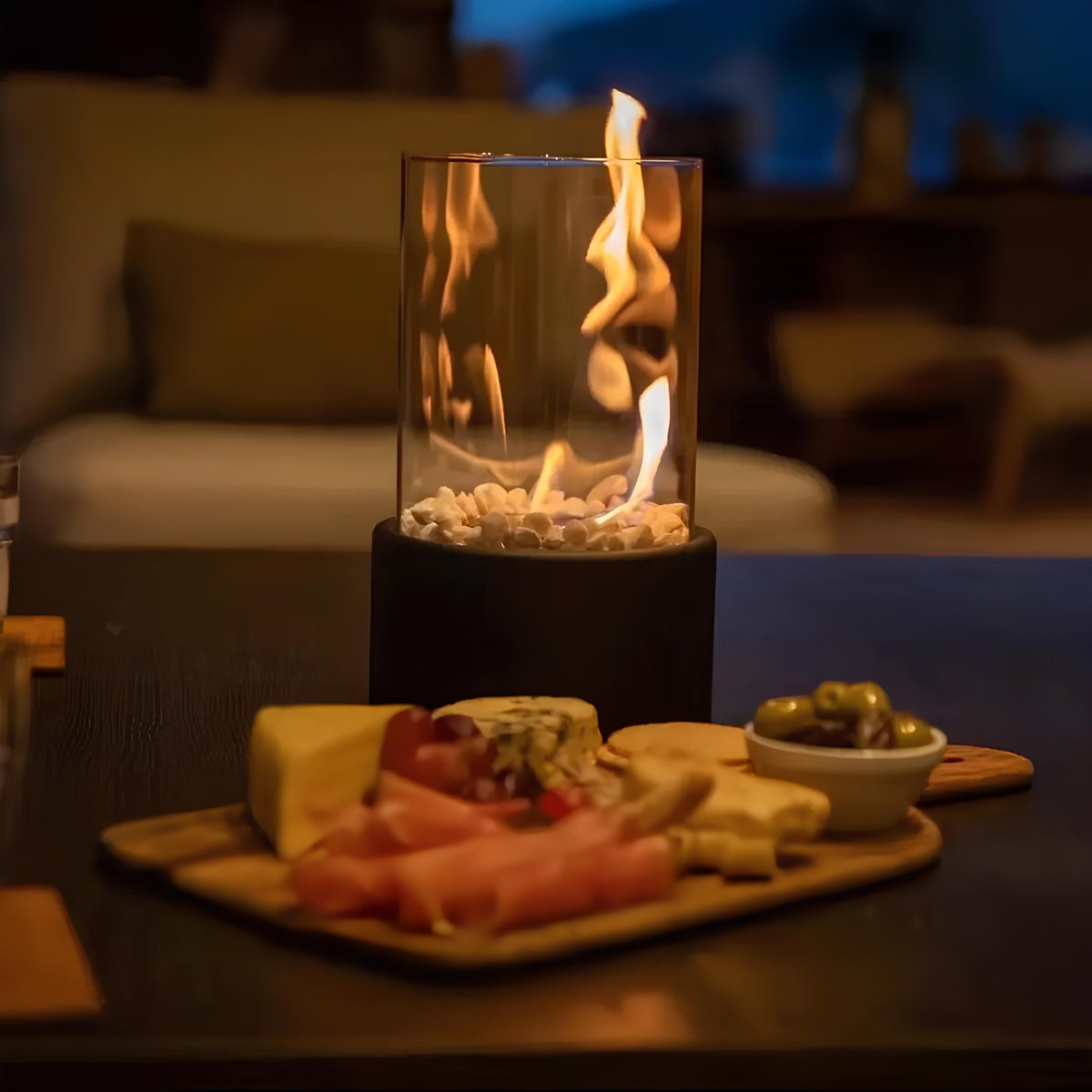 Black oil lamp flame beside a cheese and charcuterie board — Casa Norex