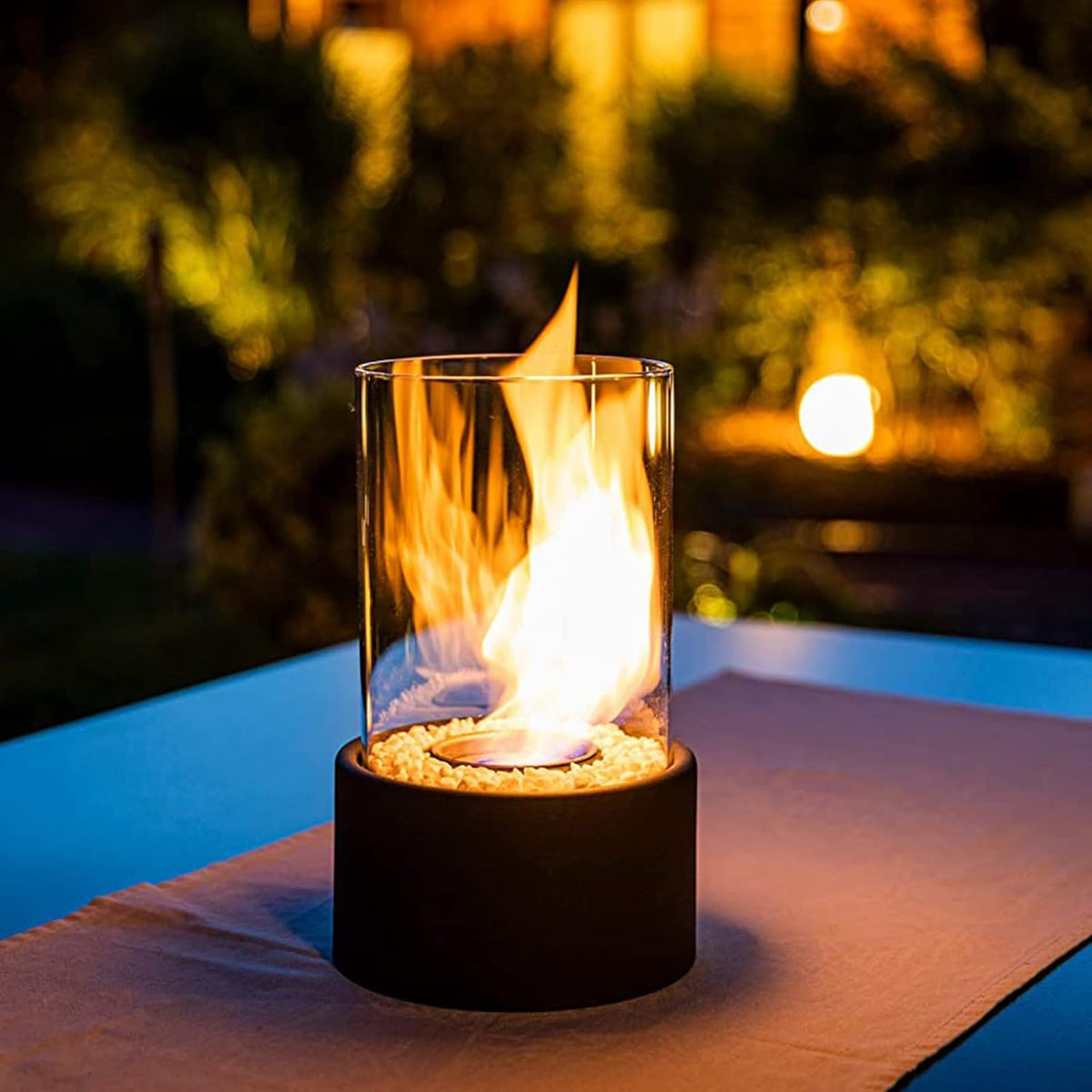 Black oil lamp flame glowing on a poolside table at dusk — Casa Norex