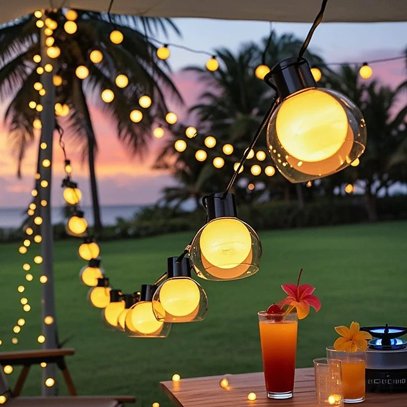 Solar globe string lights above an outdoor drinks table at sunset | Casa Norex