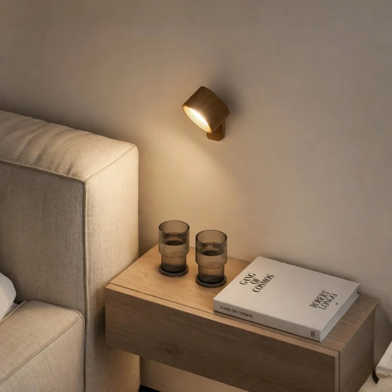 Cordless wall lamp above a bedside table with glasses and a book — Casa Norex