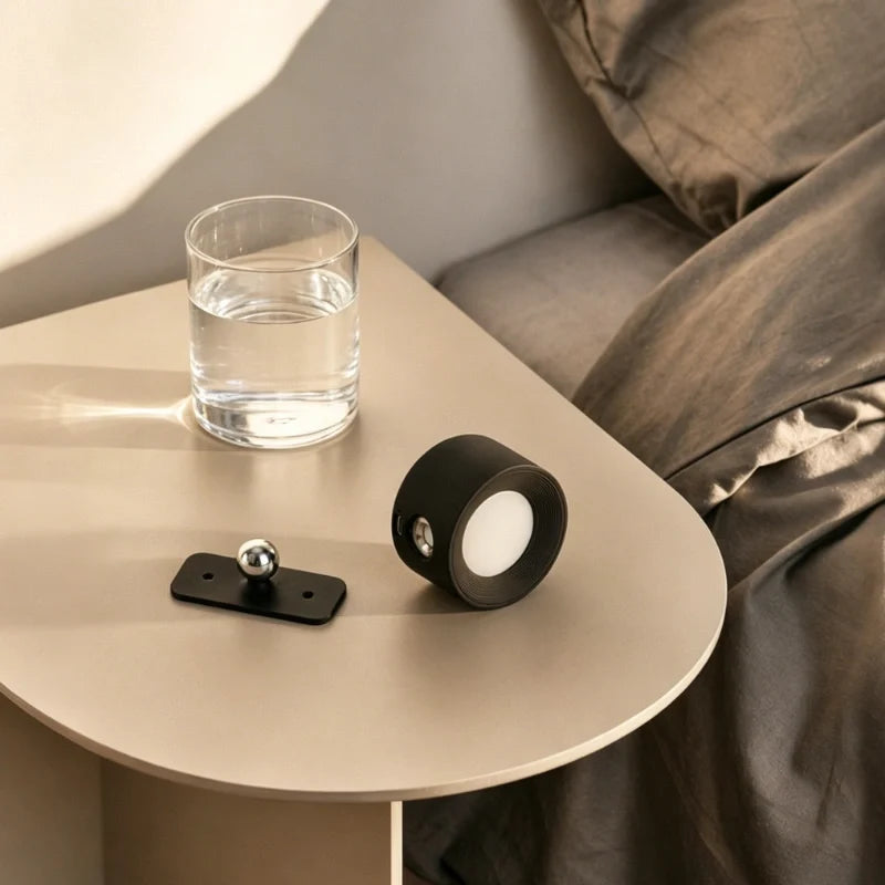 Hand-held round lamp on a bedside table beside a glass of water — Casa Norex