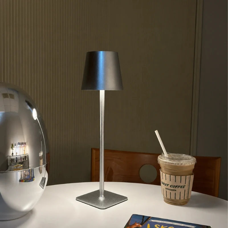 Silver-blue table lamp on a table beside an iced drink — Casa Norex