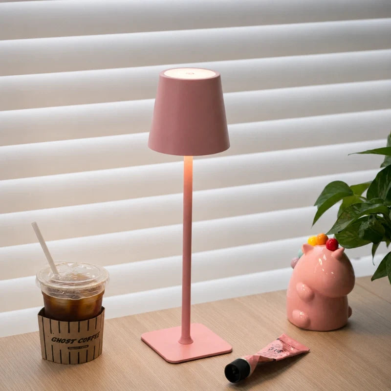 Matte pink table lamp on a window-side table with a plant — Casa Norex