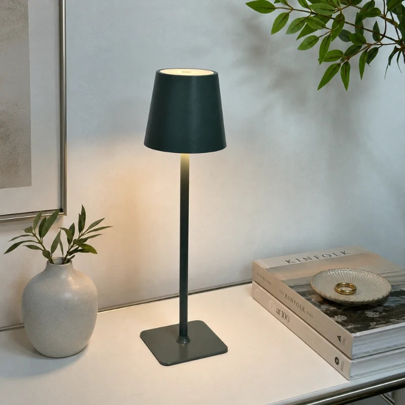 Dark green-grey table lamp on a desk with books and a vase — Casa Norex