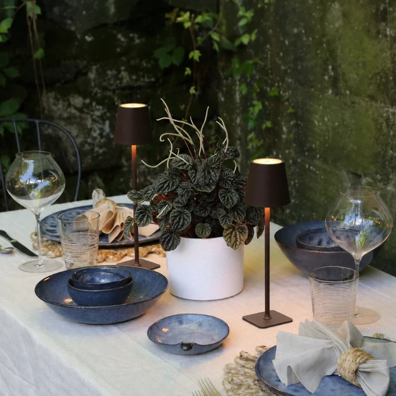 Small table lamp glowing among blue dishes and glasses at a table — Casa Norex