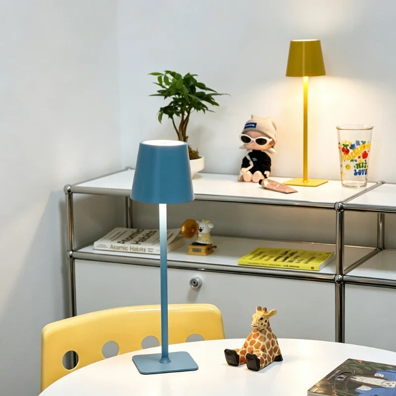 Matte blue lamp in the foreground with a yellow lamp behind it on a shelf — Casa Norex