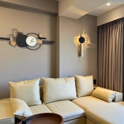 Solo wall sconce above a cream corner sofa in a living room with a wall clock — Casa Norex