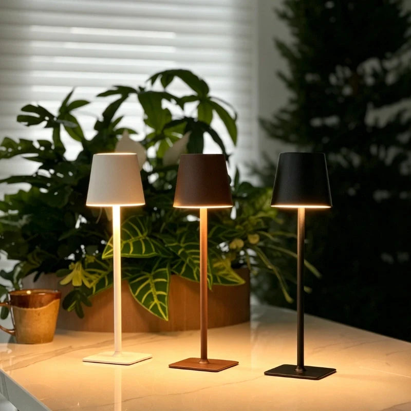 Three table lamps in white, brown and black on a dining table with plants — Casa Norex