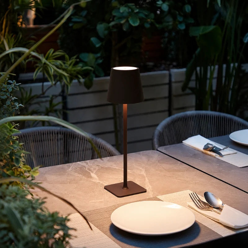 Matte brown cordless table lamp on a patio dining table beside a place setting | Casa Norex