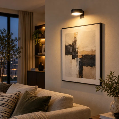 Cordless picture light over a framed abstract artwork beside a sofa