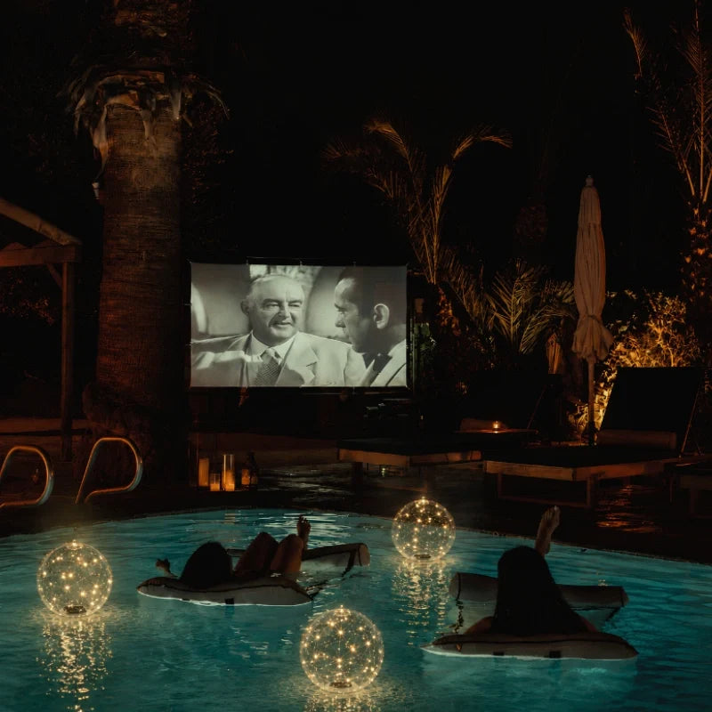 Solar light orbs glowing on a poolside night scene