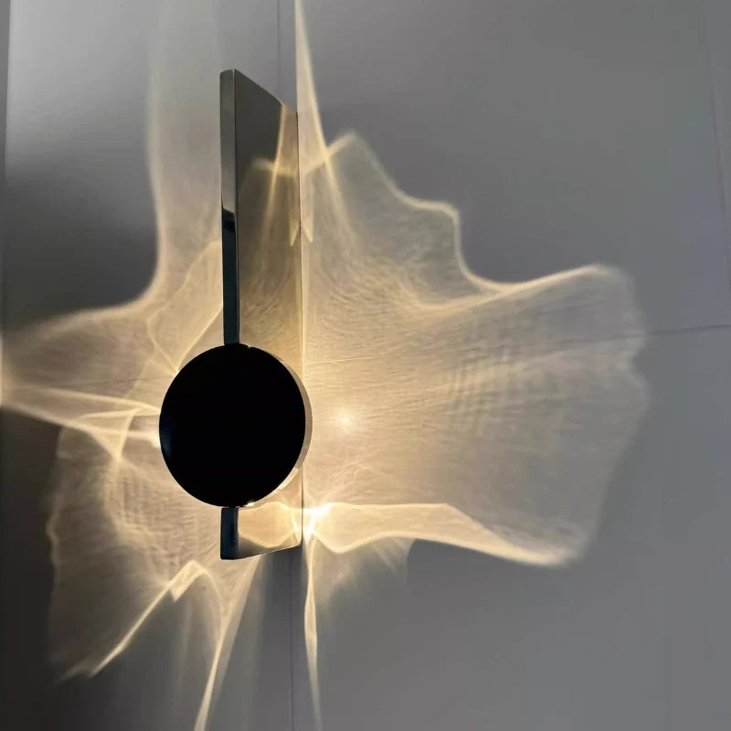 Side view of the Solo wall sconce head with warm light spreading across a gray wall — Casa Norex