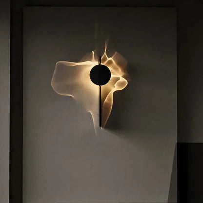 Wall sconce with round black head casting warm white ripple light on a gray wall — Solo | Casa Norex