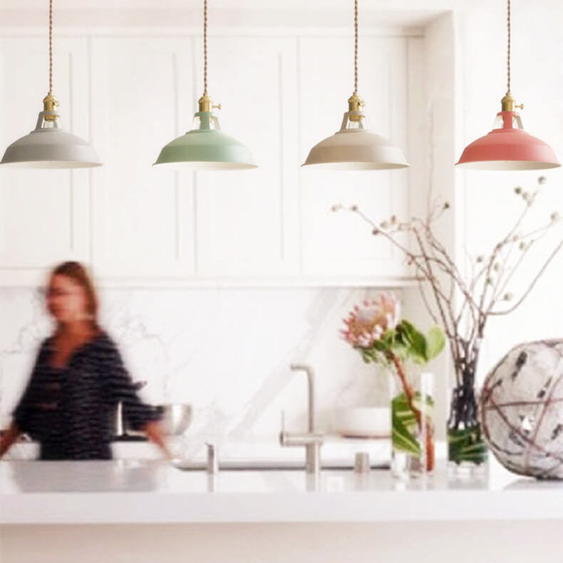 Row of four muted-color barn shade pendants above a white kitchen island — Casa Norex