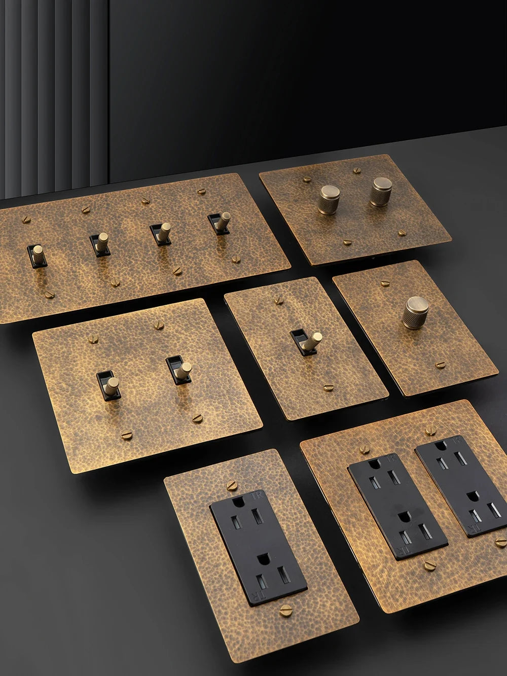 Hammered brass wall outlet panel finish close-up — Casa Norex