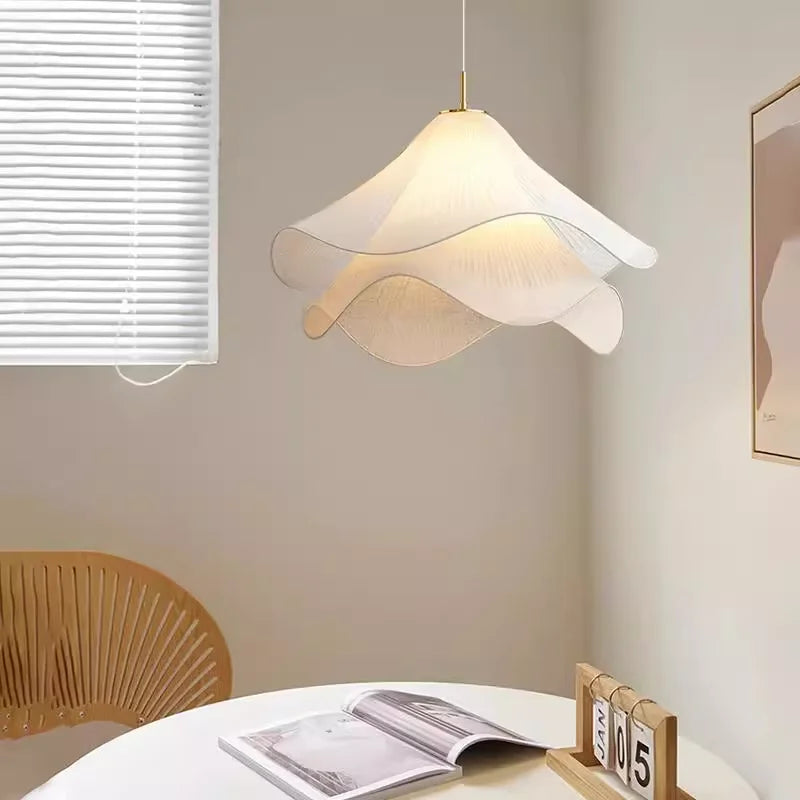 Fabric flower pendant light hanging beside a window above a round table — Casa Norex