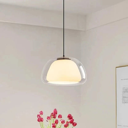 Double glass pendant light hanging in a beige dining corner with pink tulips | Casa Norex