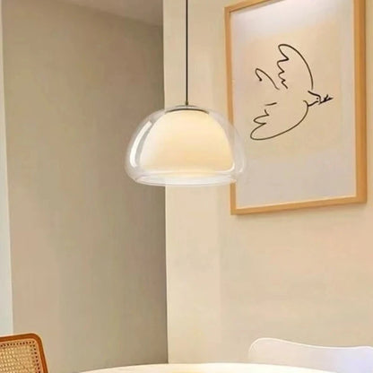 Dome glass pendant light beside framed bird line art above a dining table — Casa Norex