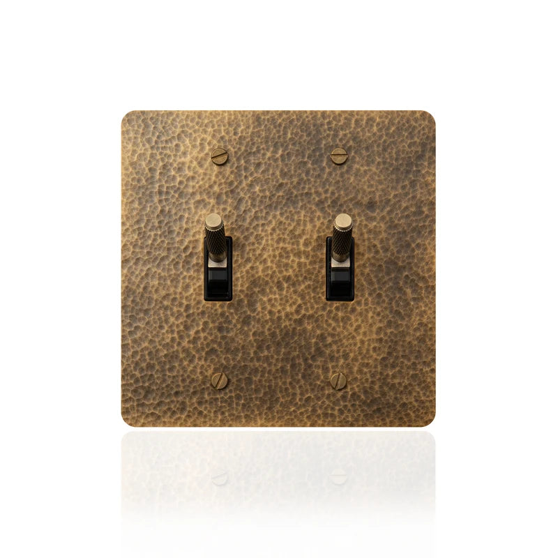 Close-up of 2-gang hammered brass toggle switch panel | Casa Norex