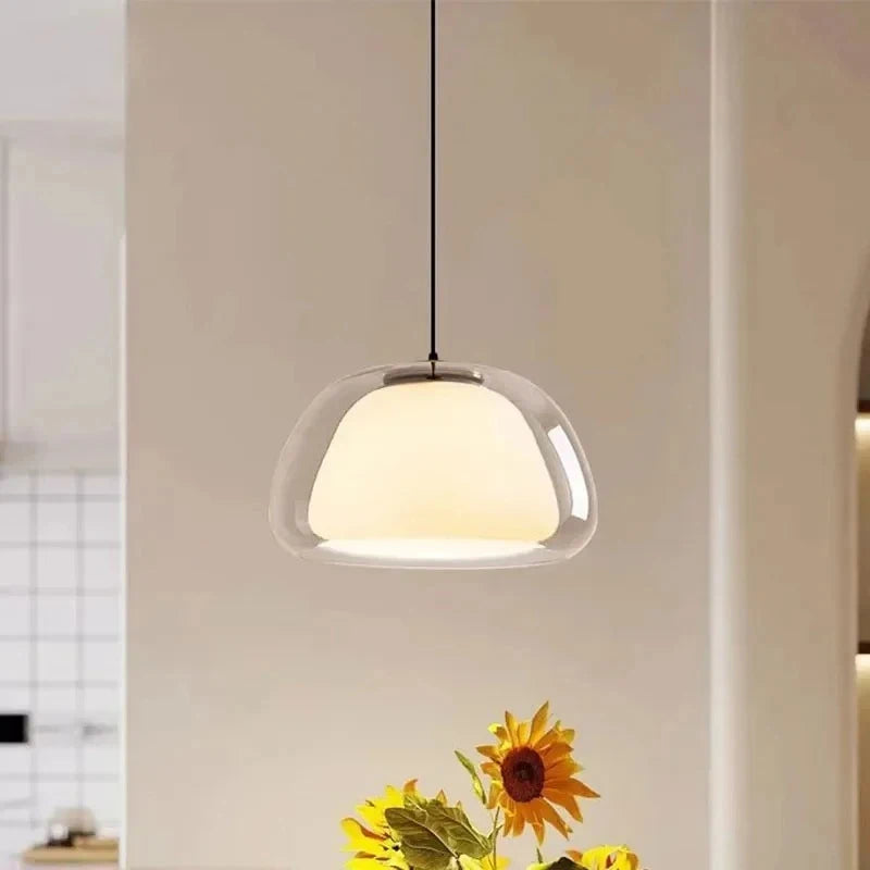 Double glass pendant light above sunflowers in a bright kitchen corner — Casa Norex