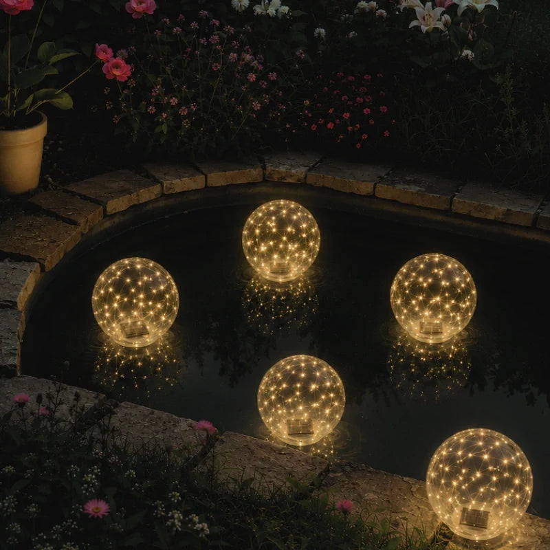 Warm white floating solar light orbs on the water beside the pool edge