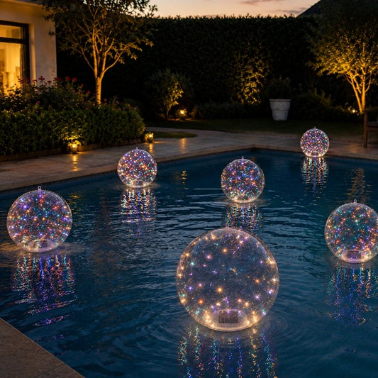 Multicolor floating solar light balls on a pool beside a garden at dusk