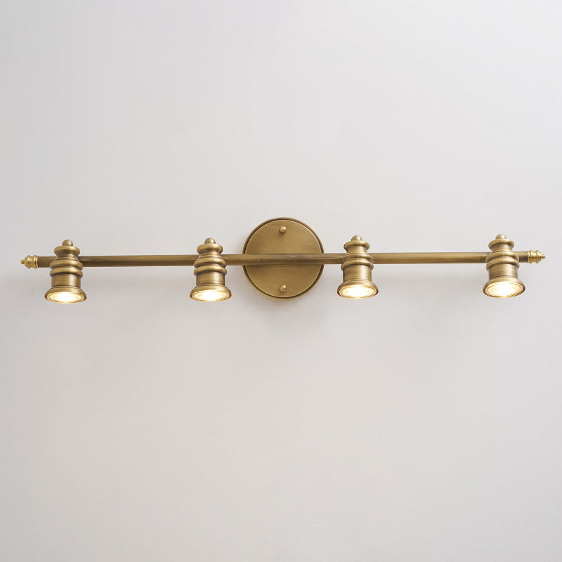 Brass wall sconce with four spotlight heads on a light grey wall | Casa Norex