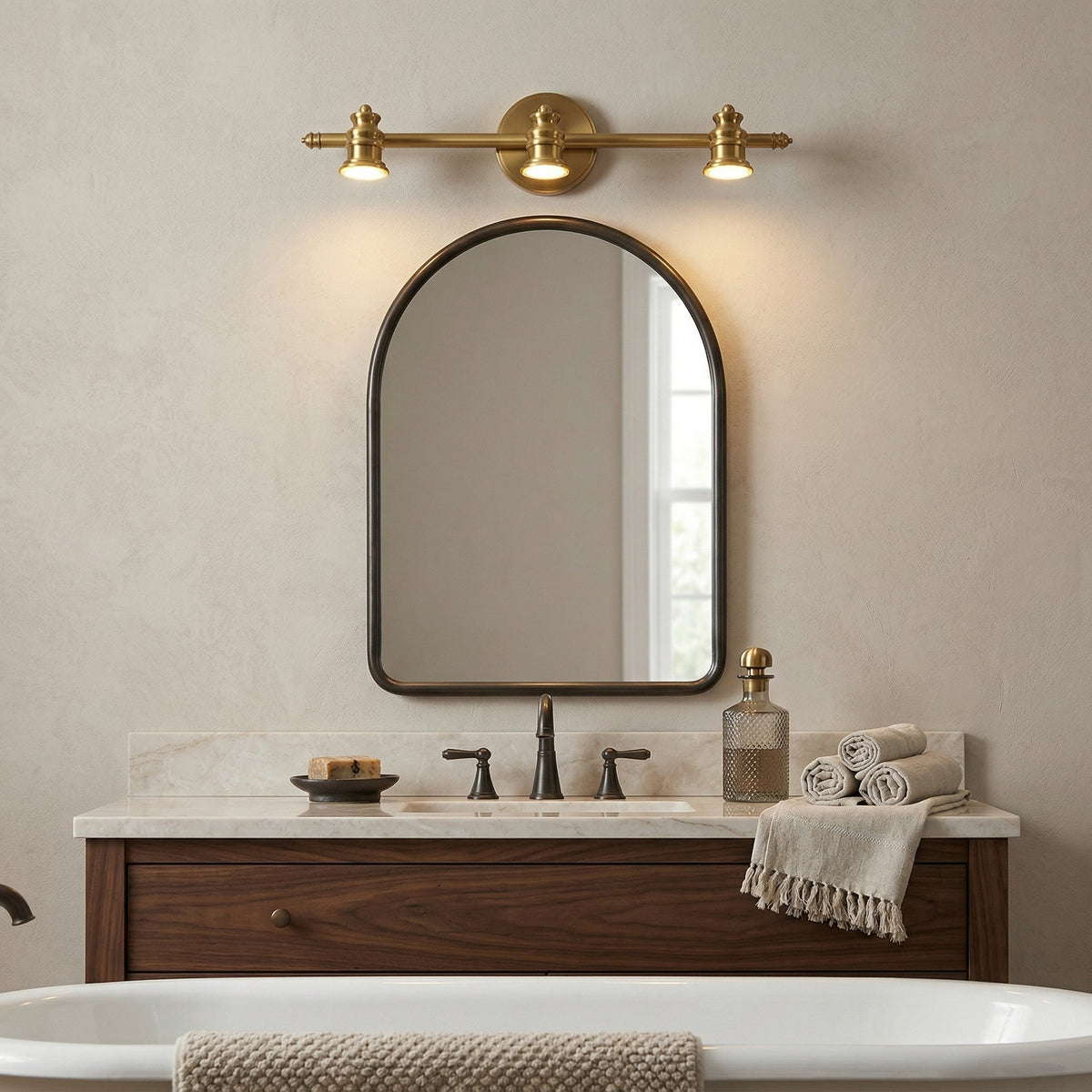 Brass spotlight bar above an arched mirror over a bathroom vanity — Casa Norex