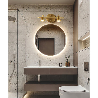 Brass spotlight bar above a round backlit mirror and floating vanity — Casa Norex