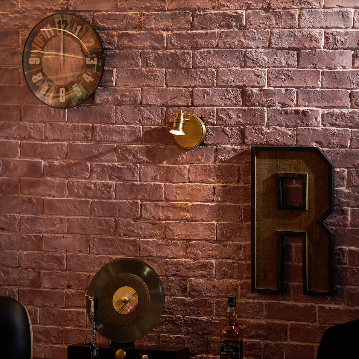 Single-head brass wall sconce on brick with decorative objects — Casa Norex
