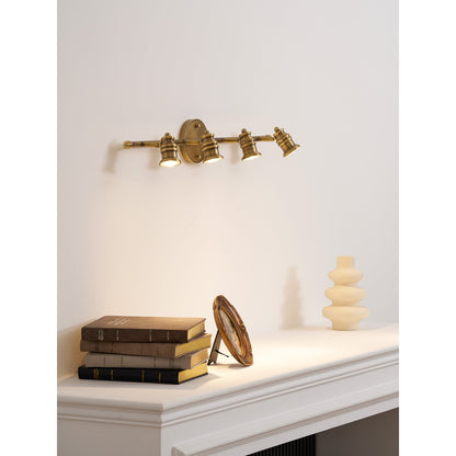 Brass spotlight bar above a white console with decor — Casa Norex