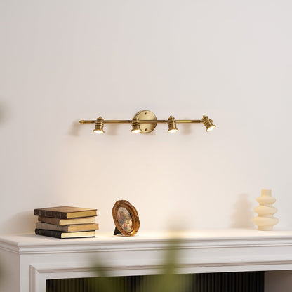Four-head brass spotlight bar above a white mantel — Casa Norex