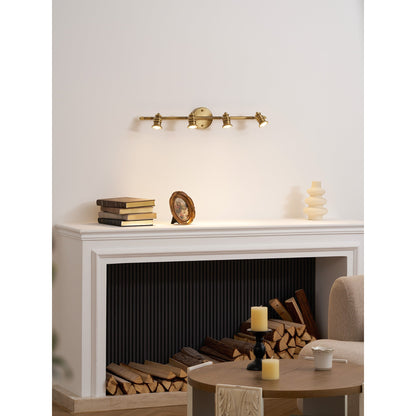 Brass spotlight bar above a mantel with books and ornaments — Casa Norex
