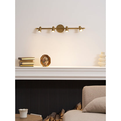 Brass spotlight bar above a console with a sofa behind — Casa Norex