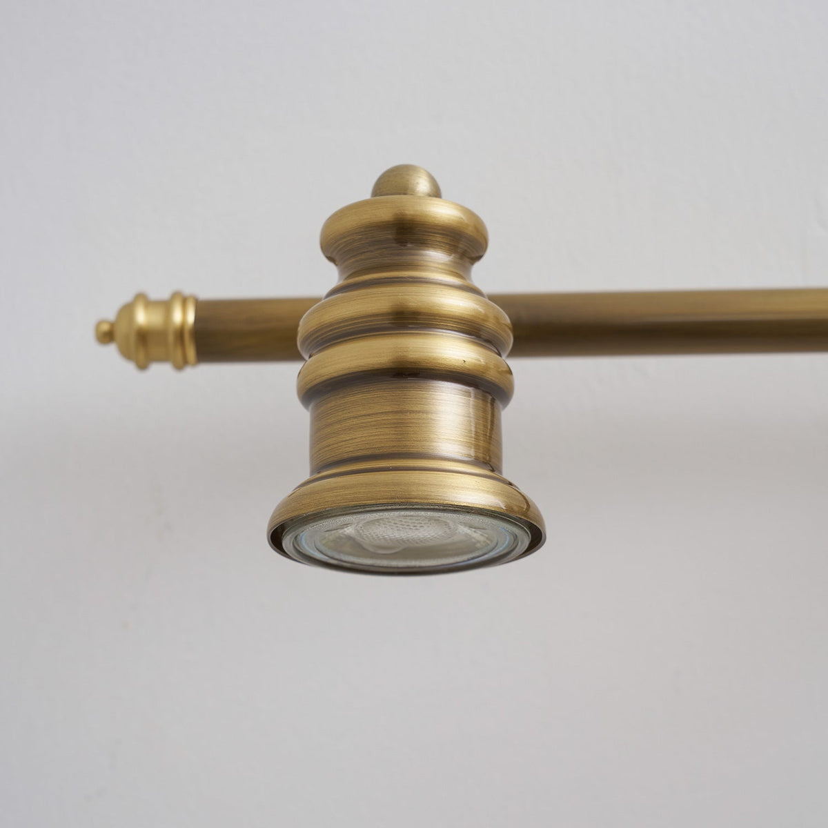 Extreme close-up of a turned-brass spotlight head and bar — Casa Norex