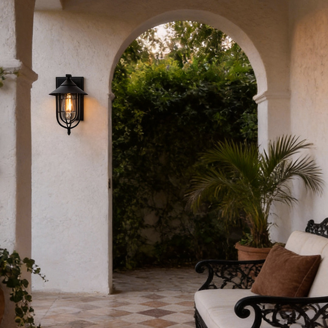 Lantern outdoor wall light beside arched door with black metal cage — Casa Norex