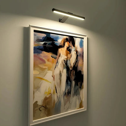 Gold picture light above a framed portrait painting on a gray wall — Casa Norex