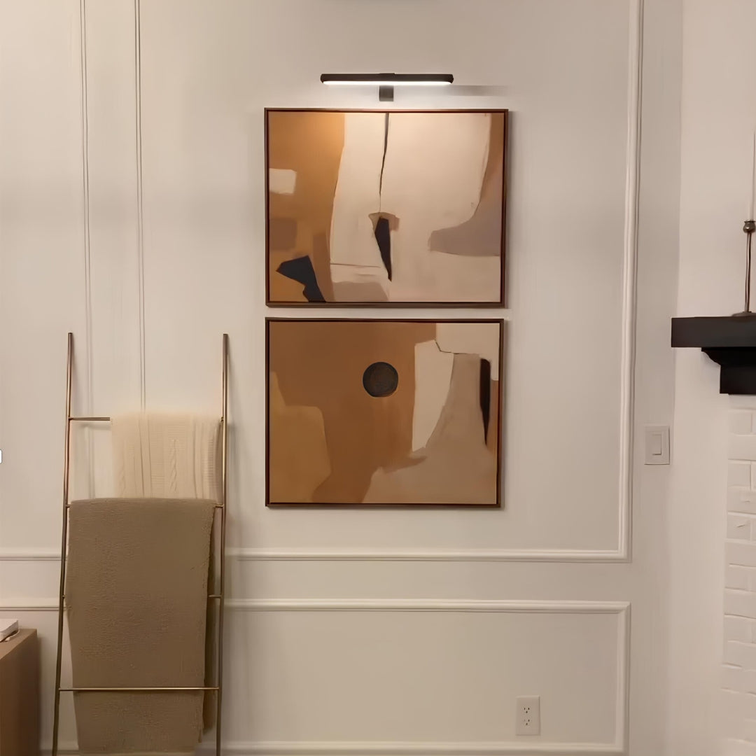 Black picture light above abstract art in a white room — Casa Norex