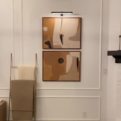 Black picture light above abstract art in a white room — Casa Norex