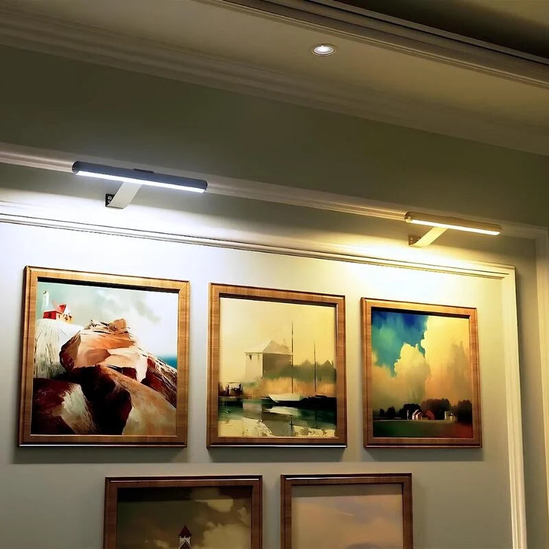 Picture lights above a gallery wall of framed paintings — Casa Norex