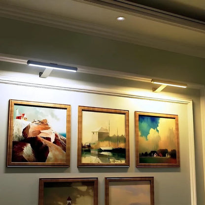 Picture lights above a gallery wall of framed paintings — Casa Norex