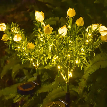 Yellow faux rose stake lights glowing among garden foliage | Casa Norex