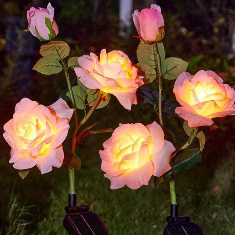 Pink and peach rose stake lights glowing in a garden at night — Casa Norex