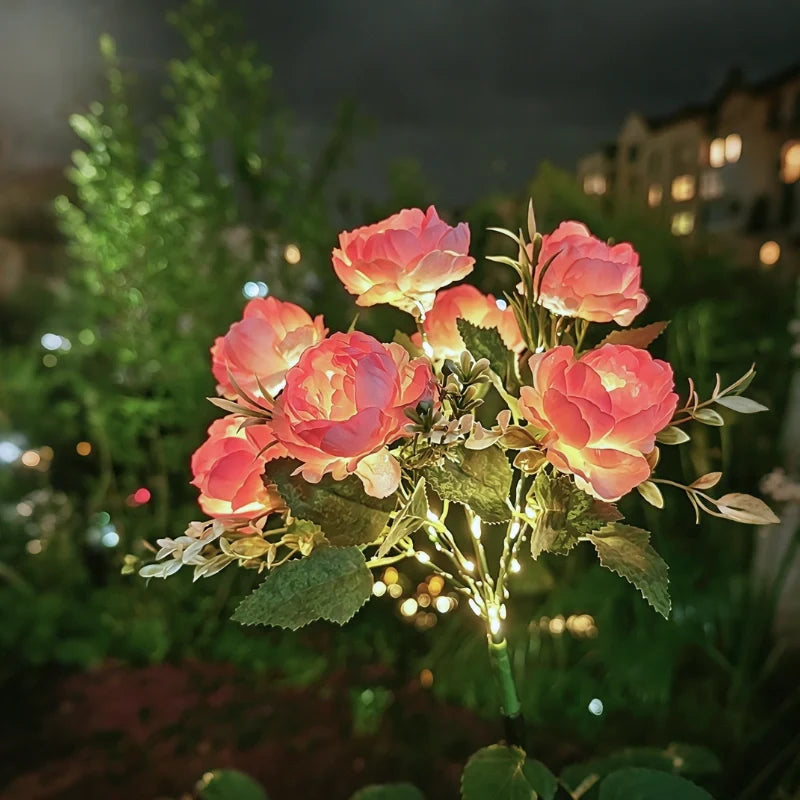 Pink peony stake lights lit in a garden at night — Casa Norex