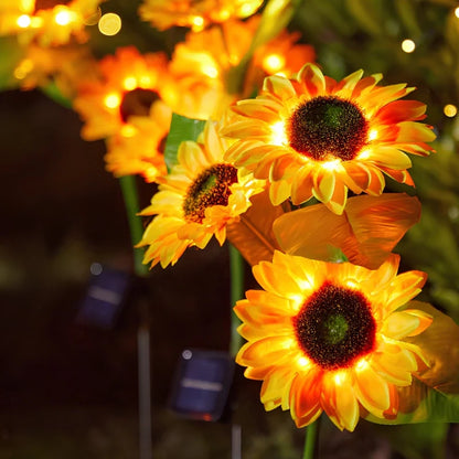 Sunflower stake lights glowing orange and yellow at night — Casa Norex